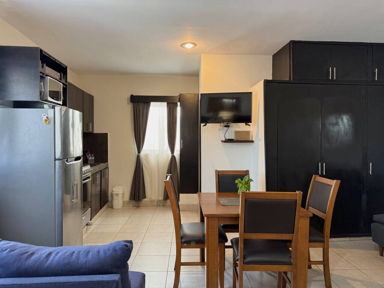 Un espace de vie compact comprenant une kitchenette, un coin repas et un canapé.