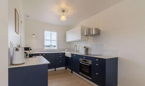 A modern kitchen with a built-in oven, a sink, and a window providing natural light. - Family house near the sea in Plévenon | 6 guests | Ref 349 (PLEVENON)