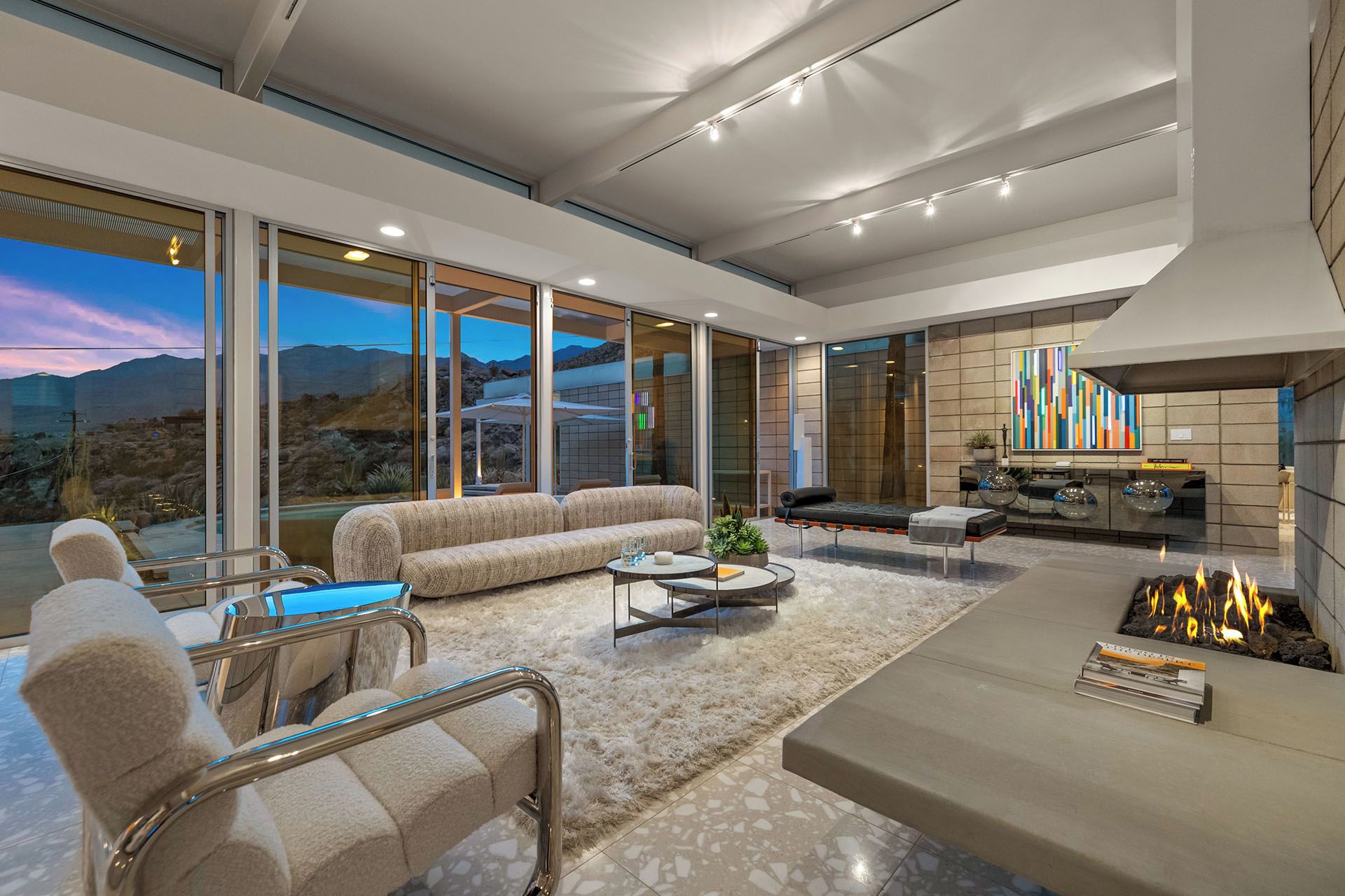 A modern living room with a sofa, armchair, and a fireplace.