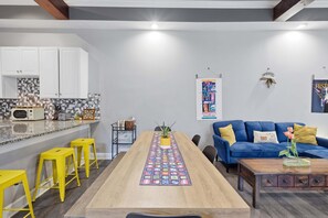 Eine moderne Küche mit weißen Schränken, einer gefliesten Spritzschutzleiste und einer Holz Arbeitsplatte.