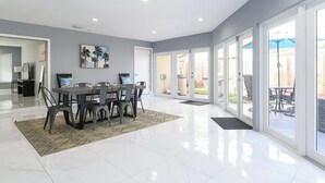 A spacious room with a dining area, a large window, and a view of the outdoors. - Private Pool 4BR · 6 Min to Fort Lauderdale Beach (Fort Lauderdale)