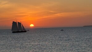 Un voilier sur des eaux calmes, au coucher du soleil.