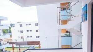 Un balcón con mobiliario de mimbre y vista a un edificio residencial.