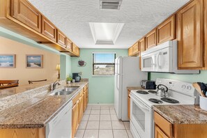 Fully equipped kitchen with granite counters, perfect for cooking beach-day favorites - Beachfront Cape Canaveral 2BR Condo W/ Private Balcony, Heated Pool, Hot Tub & Beach Access 🏖️ (Cape Canaveral)