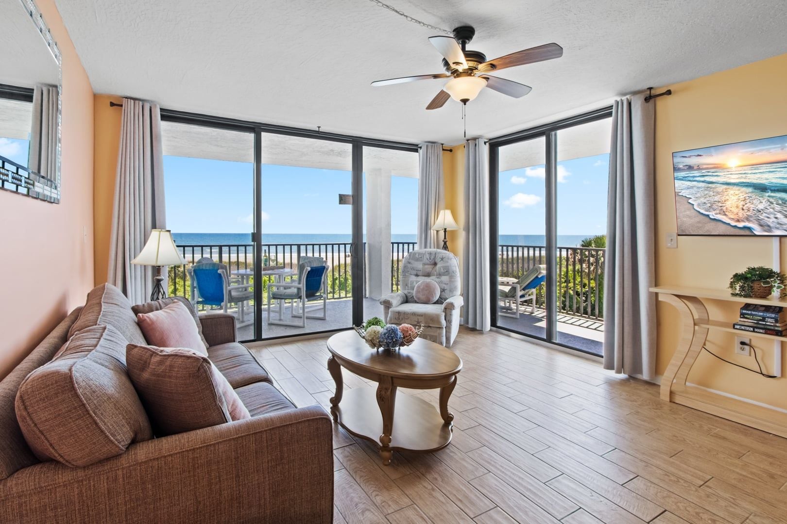 Een ruim balkon met uitzicht op de oceaan, voorzien van een bank, stoelen en een tafel.