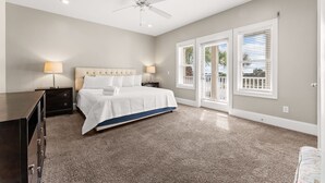 A bedroom with a bed, nightstands, a dresser, a ceiling fan, and a view through the window blinds. - Gulf Views - Private Pool - 4 Bedroom (Panama City)