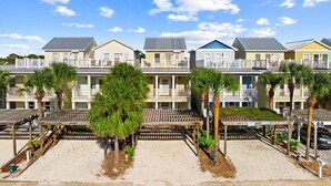 A beachfront hotel with multiple-story buildings, balconies, and palm trees. - Gulf Views - Private Pool - 4 Bedroom (Panama City)