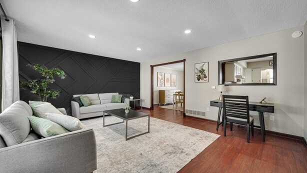 Una sala de estar moderna con sofá, mesa de centro y escritorio con silla.