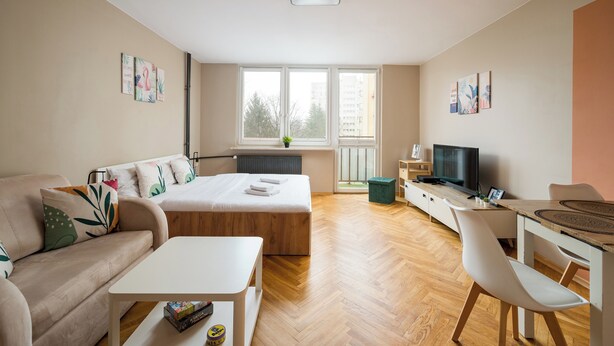 Une chambre moderne et bien éclairée, équipée d’un lit, d’un bureau et d’une chaise.