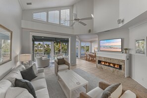 Amplia sala de estar con chimenea, asientos cómodos y un televisor grande.