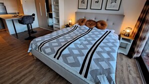 A modern bedroom with a large bed, a desk, and a wardrobe. - Studio Landskron Seezugang by Interhome (Ossiacher See)