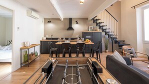 Una cocina moderna con comedor, mesa de fútbol y escalera.