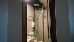 A compact bathroom with a toilet, sink, and shower area. - Villa Rosita Hotel Naga City (Naga)
