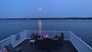 A deck with outdoor seating and a view of the water.