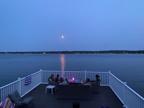 Eine Terrasse mit Sitzgelegenheiten und Blick auf das Wasser.