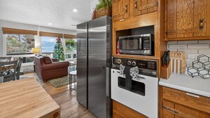 Eine moderne Küche mit Holzausstattung, Edelstahlgeräten und Blick ins Freie.