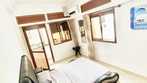 A bedroom with a bed, a small table, and a window. - Cosy seaside apartment (Tanger)