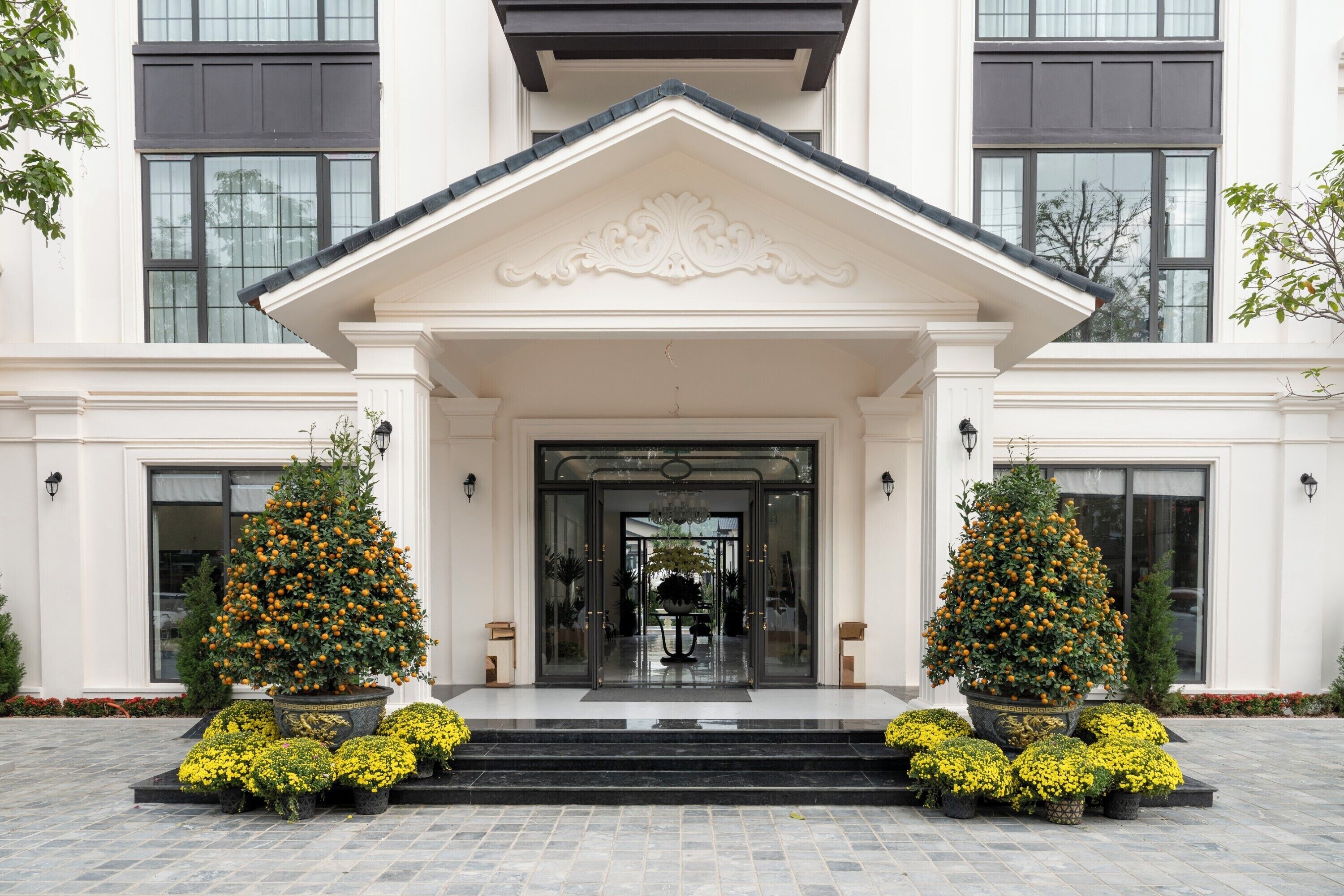 A grand entrance with a white facade, large windows, and a central decorative element above the door.