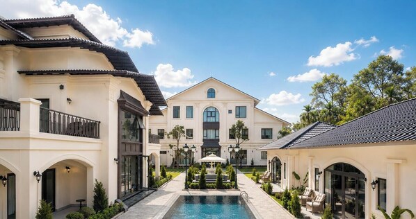 A large building with a pool, surrounded by greenery and a clear sky. - Narci Resort Tam Coc (Hoa Lu)
