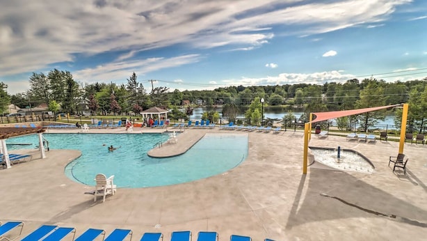 Una piscina amb gandules blaves, un petit pavelló i vista a un llac.