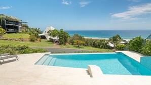 Una piscina con vista al océano y a la playa.