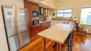 Una cocina moderna con electrodomésticos de acero inoxidable, armarios de madera y una isla grande.