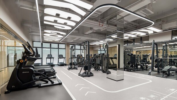 Ett modernt gym med löpband, styrketräningsmaskiner och speglar.