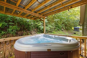 A hot tub under a wooden pergola with a view of a lush garden. - Rustic Retreat — Easy Access, Peaceful Setting, Close to Everything (Sevierville)