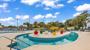 Ein Pool mit kreisförmigem Design, umgeben von Liegestühlen und Topfpflanzen.