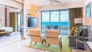Une chambre d’hôtel moderne dotée d’un balcon, d’une télévision à écran plat, d’un canapé et d’un coin repas.