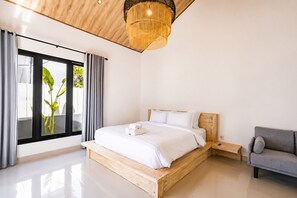 Ein modernes Schlafzimmer mit einem hölzernen Bett, einem grauen Sofa und einem großen Fenster mit Vorhängen.