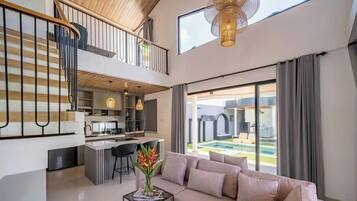 Interior moderno com cozinha, sala de jantar e sala de estar com uma grande janela com vista para uma piscina.