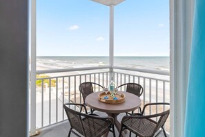 A balcony with a table and chairs, overlooking the beach. - Sandpiper Towers 408 (Satellite Beach)