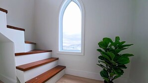 A staircase with wooden steps and a window with a view. - Saltwater Steeple- Bell Tower Suite (Port Saunders)