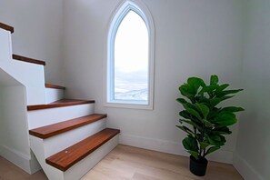A staircase with wooden steps and a window with a view.