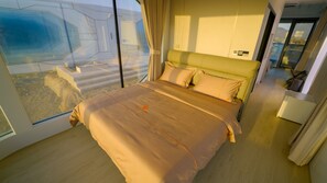 Un dormitorio moderno con una cama grande, vistas a través de un muro de cristal y un diseño minimalista.