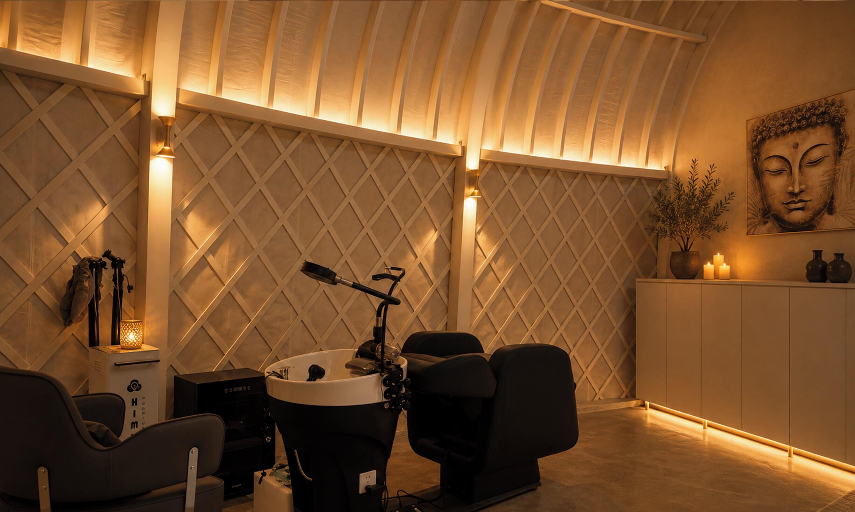 A spa room with a massage chair, a massage table, and a wall-mounted massage device.