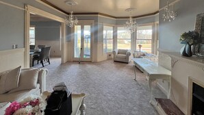 A spacious room with a fireplace, a dining area, and a large window providing a view of the outdoors. - Spacious charming lake house on Lake Hartwell (Toccoa)
