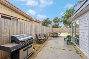 A backyard with a barbecue grill, outdoor furniture, and a wooden fence. - Newly Renovated Home in Heart of Cowes (Cowes)