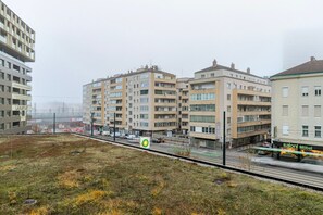 A multi-story residential building with balconies, a street in the foreground, and a sign for 'LUXURY.AT' hotel. - Blueground | Favoriten, jacuzzi, nr Belvedere (Vienna)