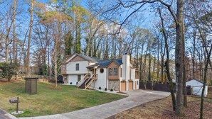 A two-story house with a front yard, a driveway, and a mailbox. - Chic & Comfy Stay • Close to Everything (Marietta)