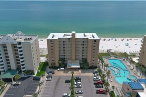 A hotel with a pool, beach view, and parking lot. - Beachfront Getaway | Sunroom with Gulf Views, Pool & Spacious 3BR Layout | BEACHBALL PROPERTIES (Gulf Shores)
