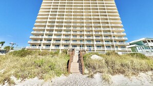 A high-rise hotel with multiple balconies and a central staircase leading to the entrance. - Beachfront 1BR + Bunks Condo w/ Pools Sleeps 6! (Panama City Beach)