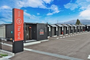 Una fila de habitaciones de hotel con un letrero rojo llamativo que indica el nombre y la ubicación del hotel.