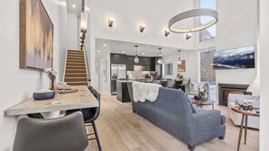 Un intérieur moderne comprenant un coin repas, un canapé et une cuisine.