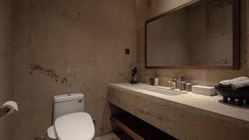 Un baño moderno con inodoro, lavabo y espejo.