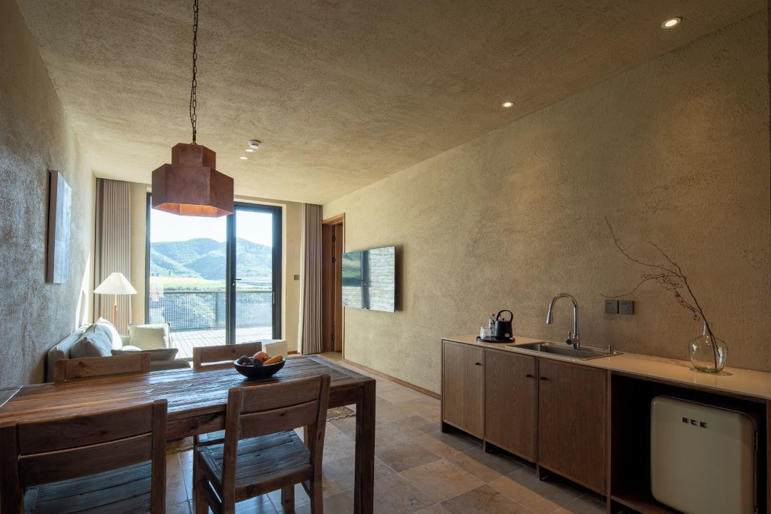 Une cuisine moderne avec des meubles en bois, un lave-vaisselle encastré et une grande fenêtre donnant sur l’extérieur.