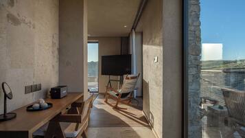 Una sala moderna con una mesa de madera, un televisor y un sillón mecededor.