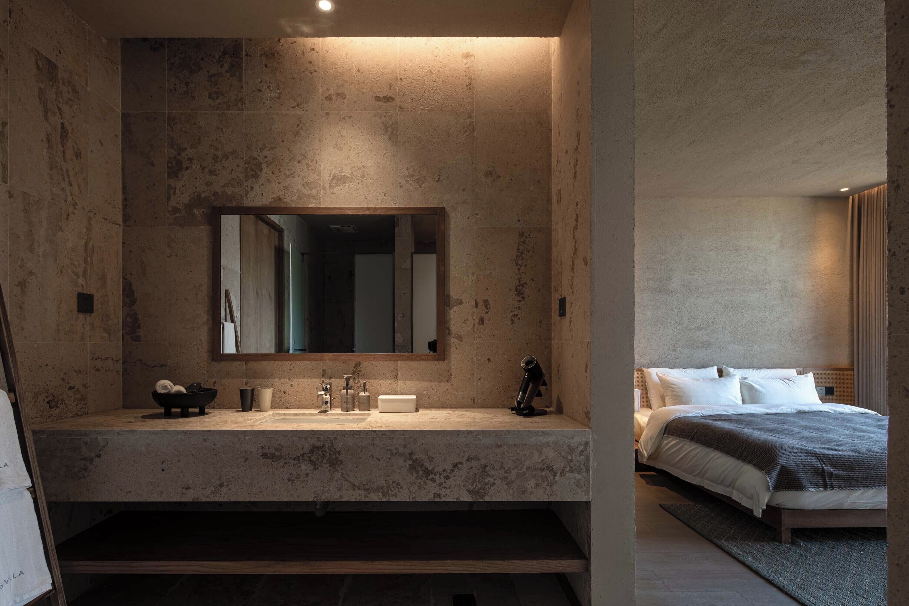 Un baño moderno con un espejo grande, un lavabo y un mueble de tocador.