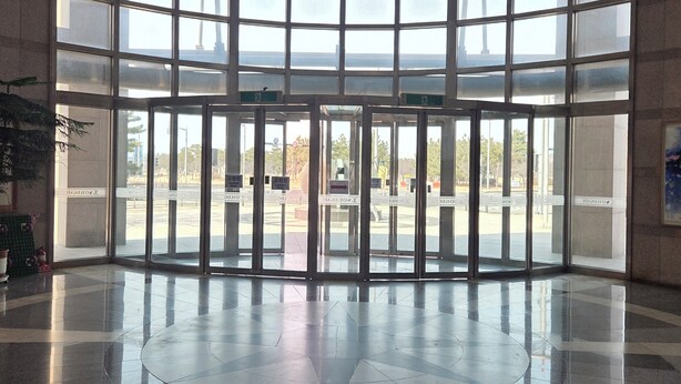 A spacious lobby with a curved ceiling, large windows, and a tiled floor. - Incheon Airport Line Guest House (Incheon)